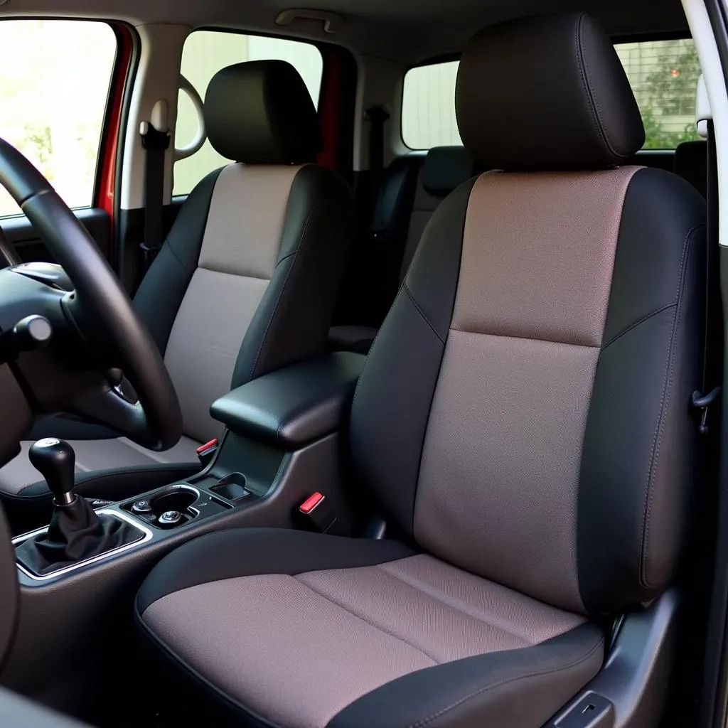 A set of cloth Nissan Frontier car seat covers installed in a truck's front seats.